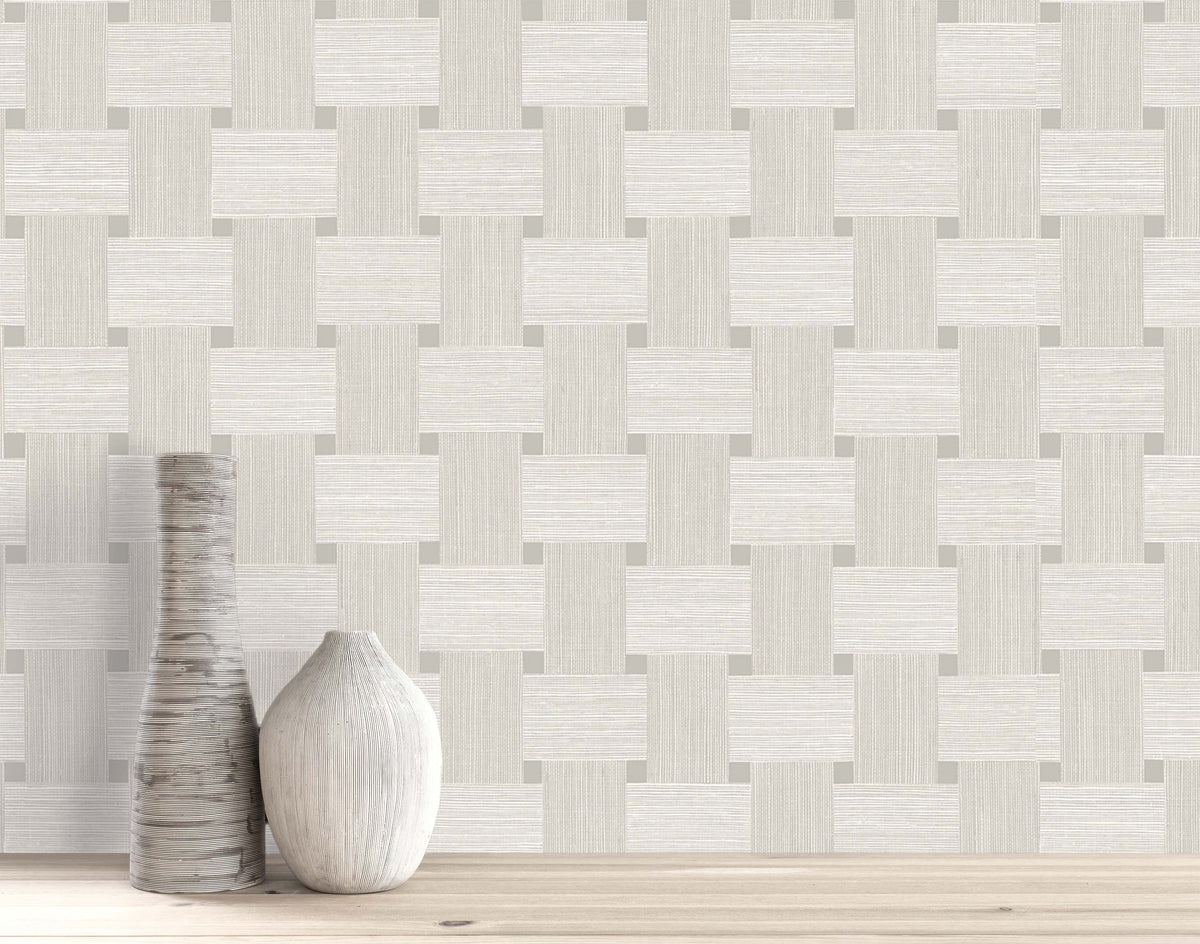 Two ceramic vases sit on wood in front of Basket Weave Commercial Vinyl wallcoverings with a geometric pattern.