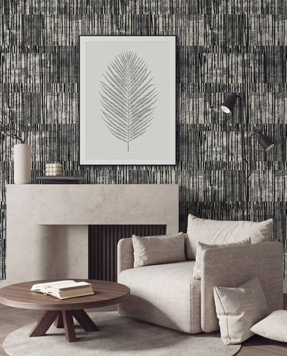 Modern living room with a beige armchair, wooden table, and framed leaf art on Abstract Vertical Stripes Wallpaper.