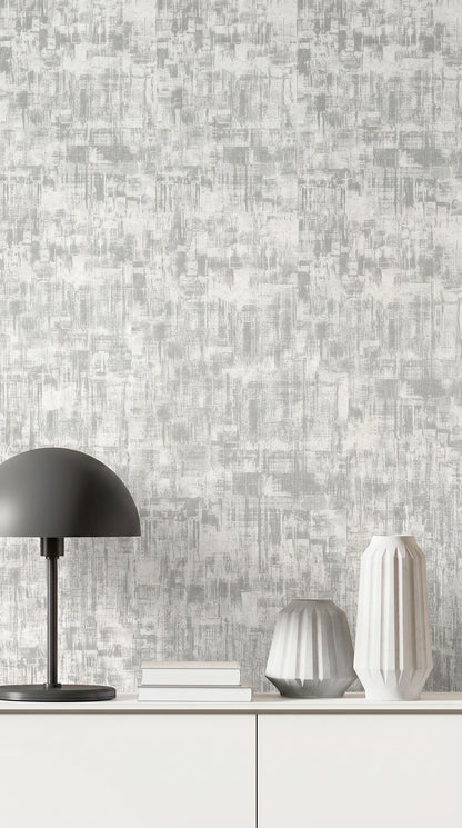 A modern lamp, books, and two textured vases sit on a white cabinet against Distressed Faux Wallpaper.