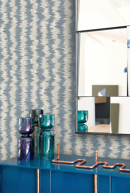 Ikat Stripe Wallpaper, mirrored wall art, glass vases, and a blue cabinet topped with copper pipe decor.