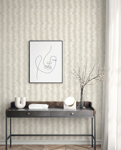 Minimalist console table with decor, abstract line art, vase with branches, and Ikat Stripe Wallpaper on the wall.