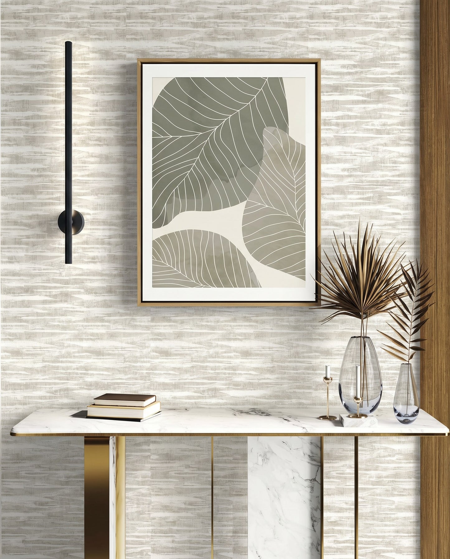 Modern console table with books, vases, and abstract leaf art on Stone Nebulite Wallpaper with a black wall sconce.