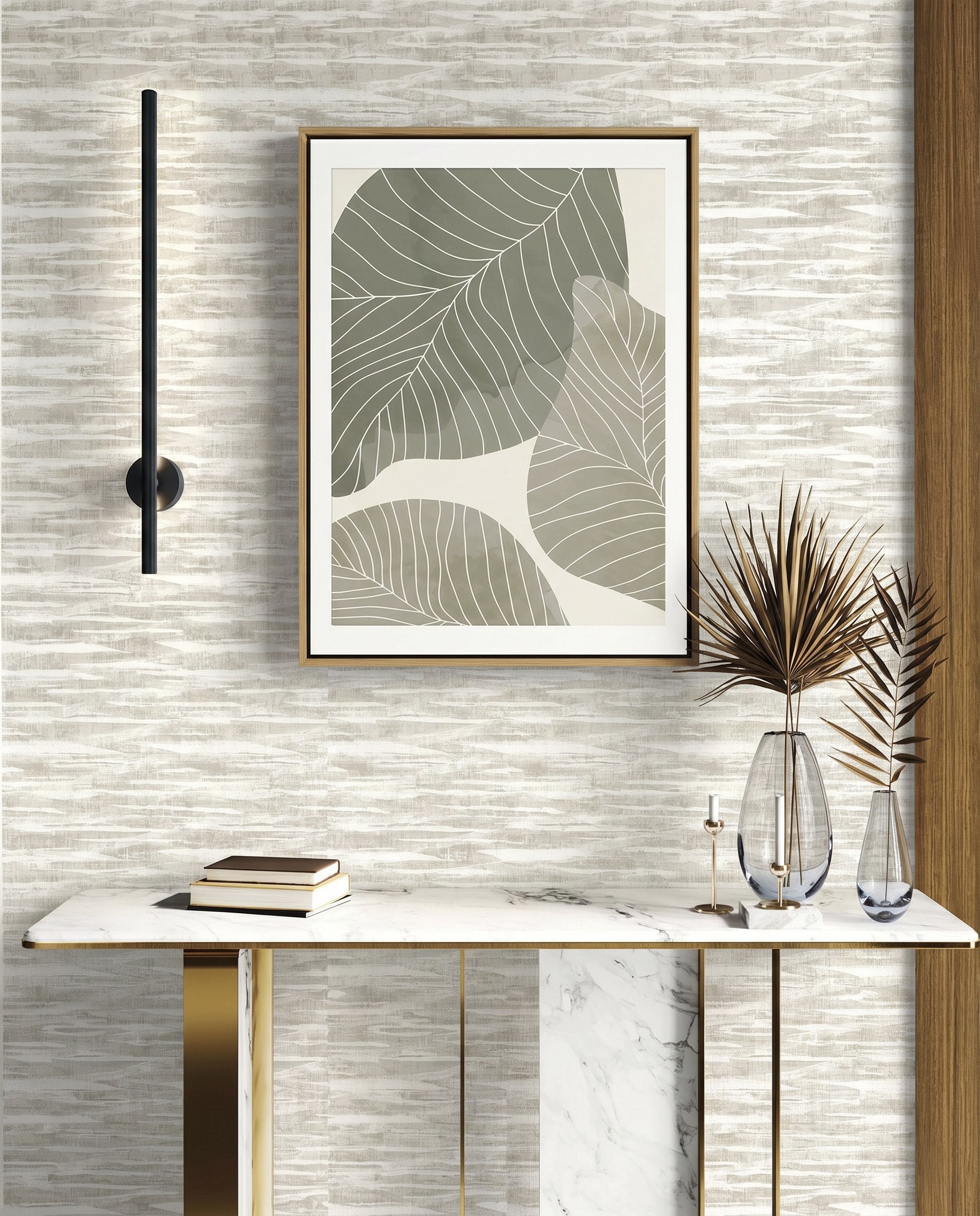 Modern console table with books, vases, and abstract leaf art on Stone Nebulite Wallpaper with a black wall sconce.