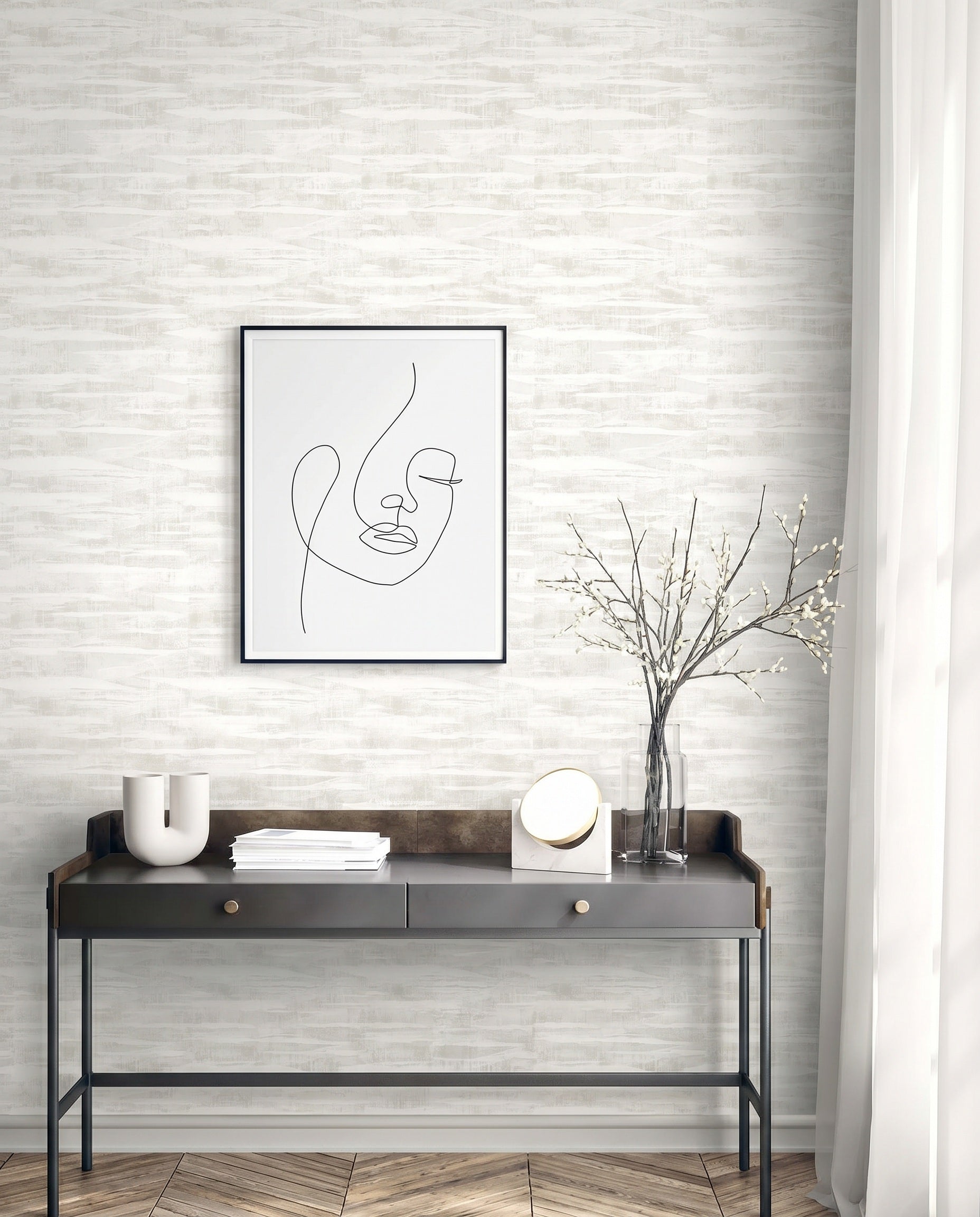 Modern console table with minimalist decor, a vase, abstract face art, and Stone Nebulite Wallpaper on a light brick wall.