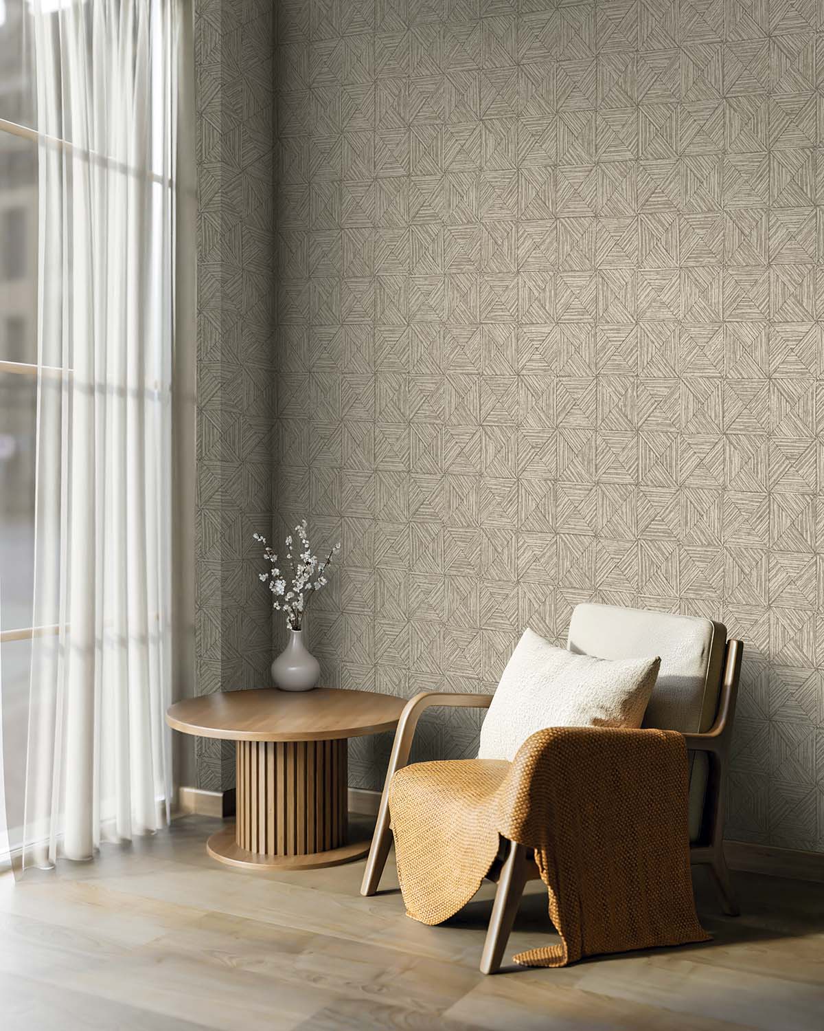 Cozy chair with pillows and blanket near round table, featuring Inlay Tile Wallpaper by a window with sheer curtains.