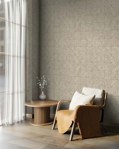 Cozy chair with pillows and blanket near round table, featuring Inlay Tile Wallpaper by a window with sheer curtains.