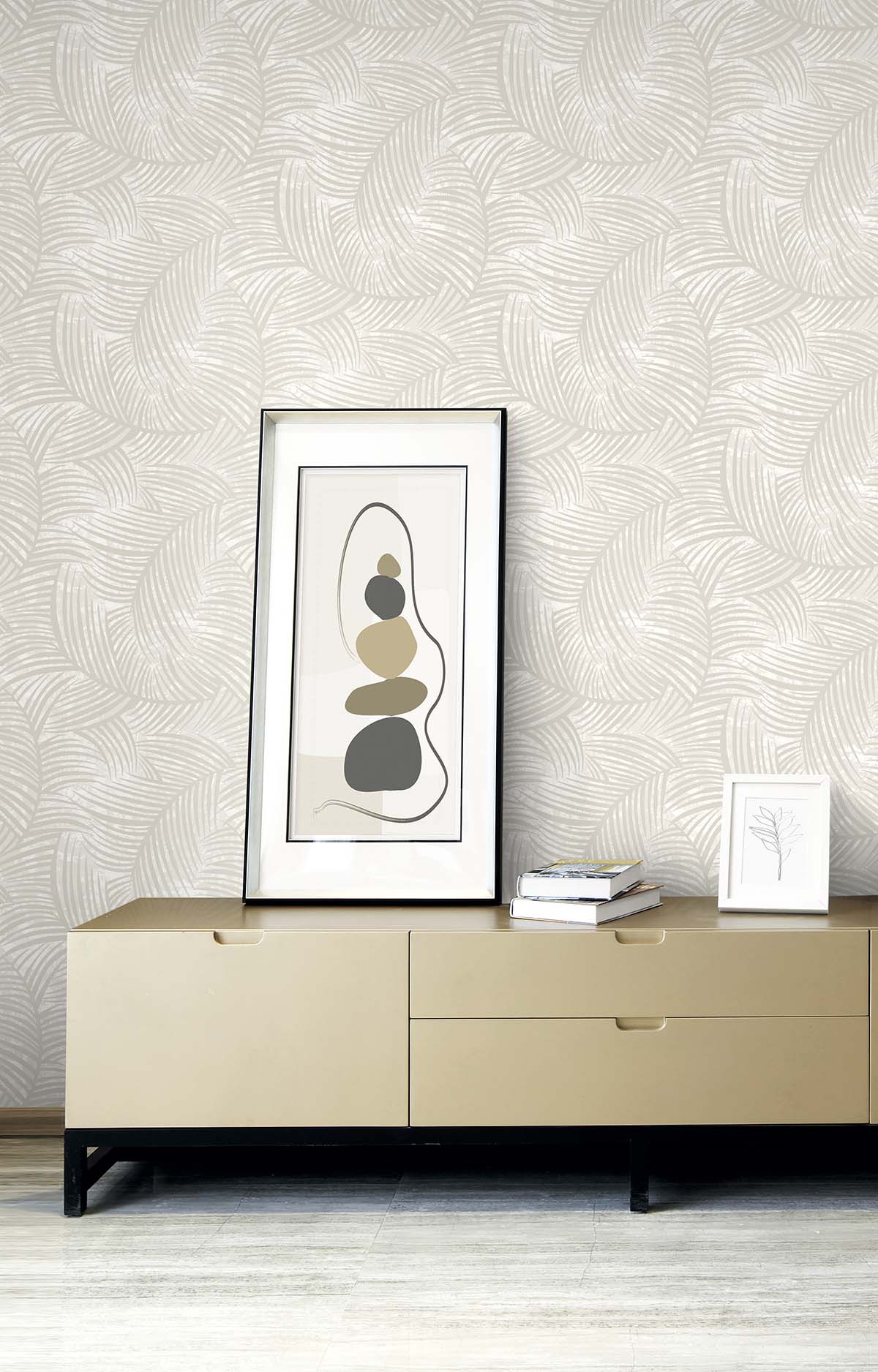 Beige sideboard with abstract art, books, and framed print against Palm Fronds Wallpaper in cream.