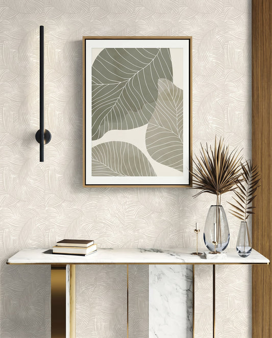 Marble console table with glass vases, books, and framed leaf art on a Palm Fronds Wallpapered wall.