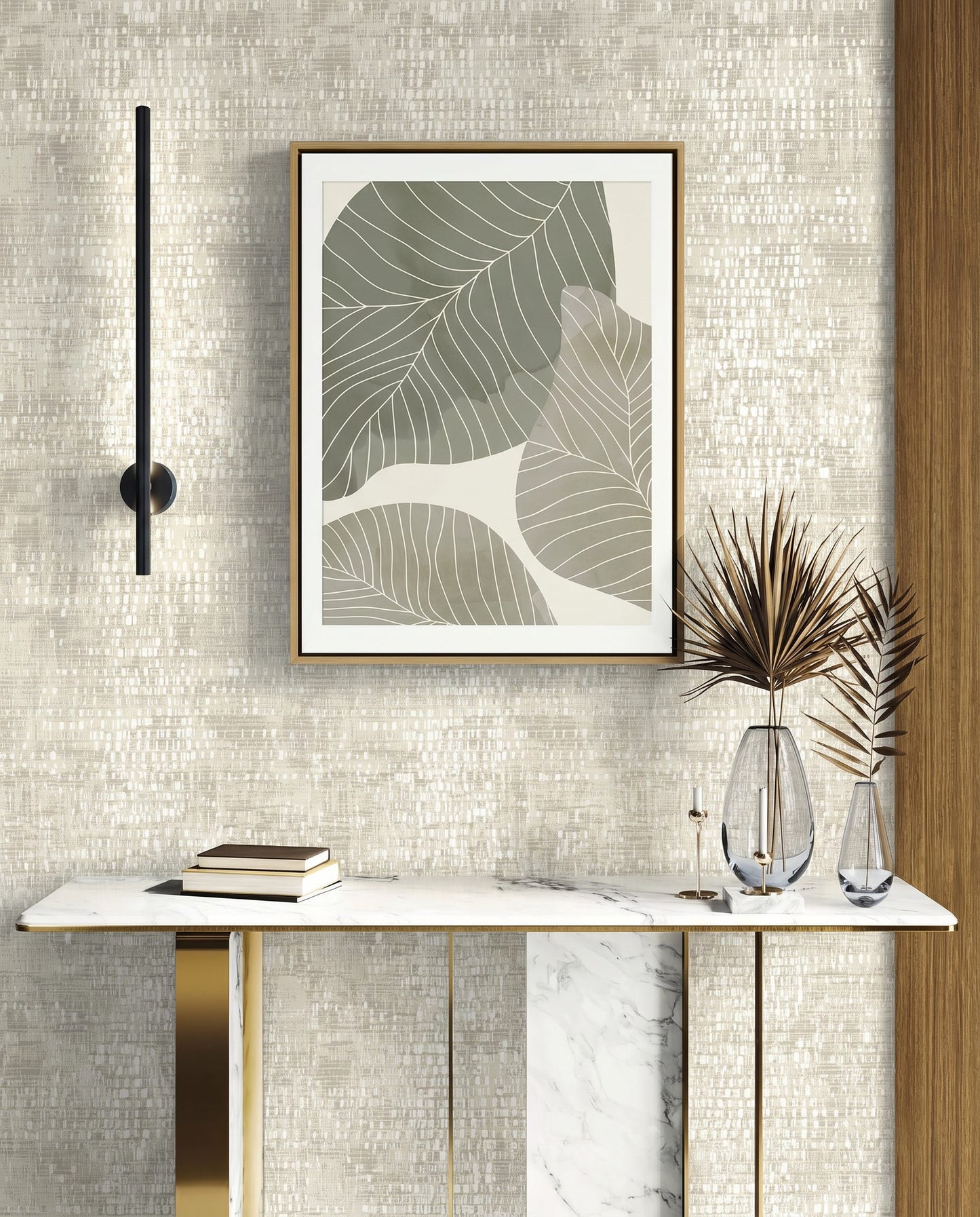 Minimalist console table with vases, books, and framed leaf art on a Dotted Wallpaper wall.