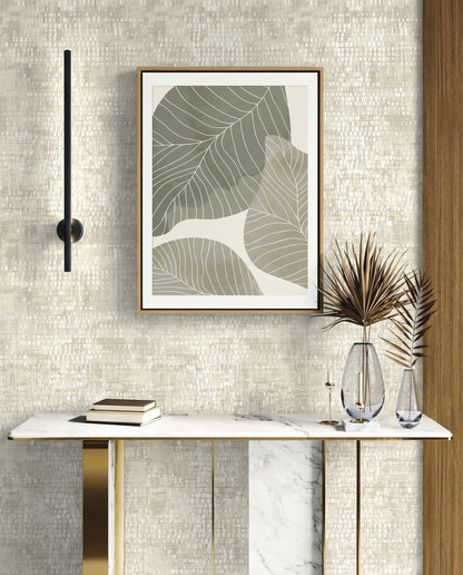 Minimalist console table with vases, books, and framed leaf art on a Dotted Wallpaper wall.