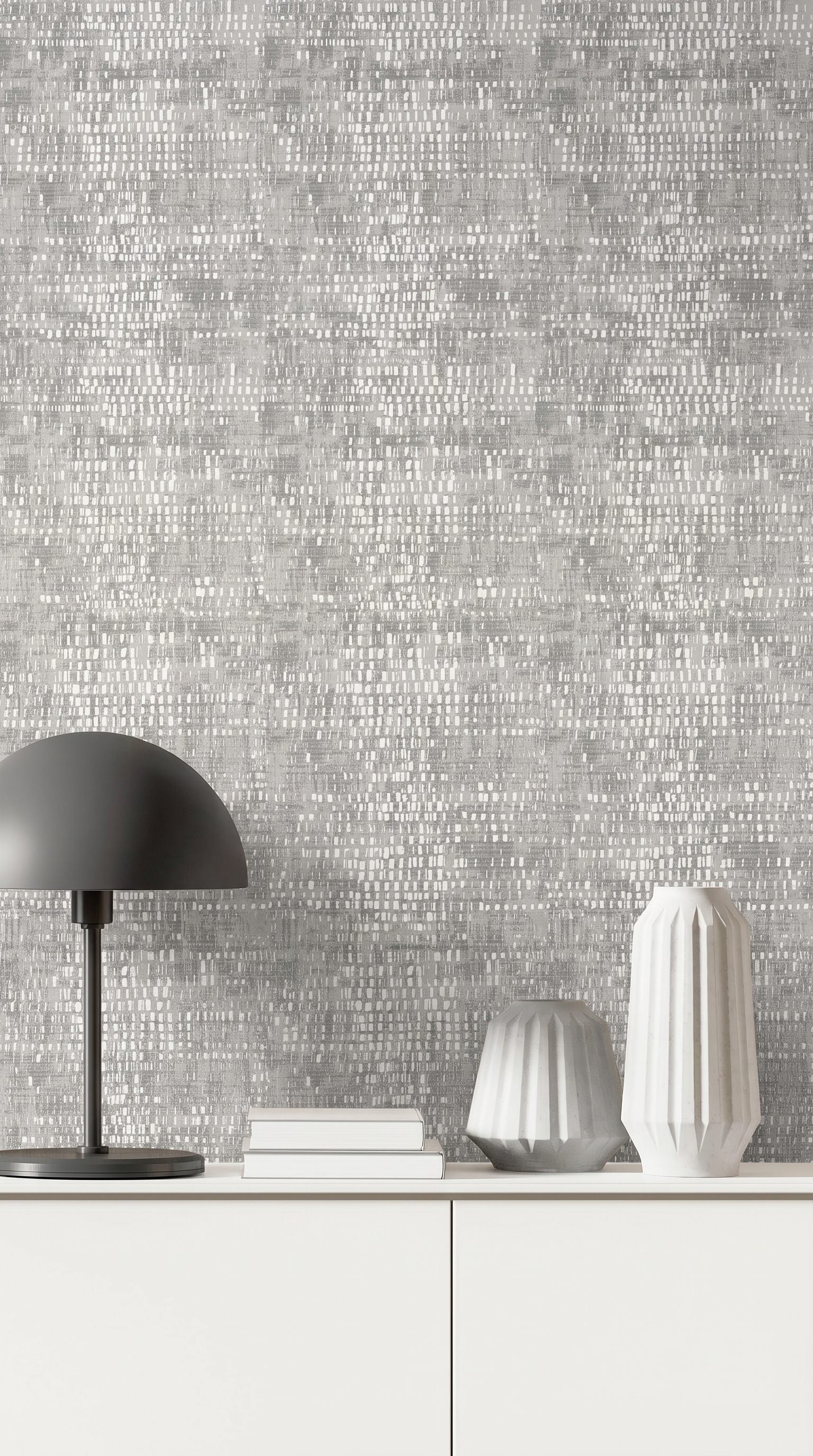 Modern minimalist decor with a black lamp and white books set against gray Dotted Wallpaper.