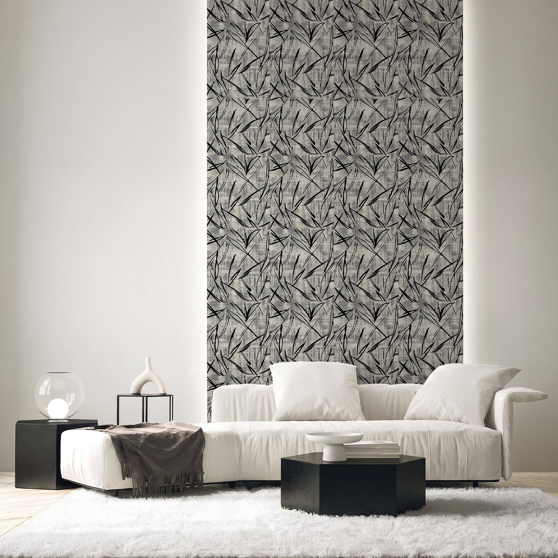 Modern living room with white sofa, black tables, and a tall wall panel featuring Brushstroke Wallpaper.