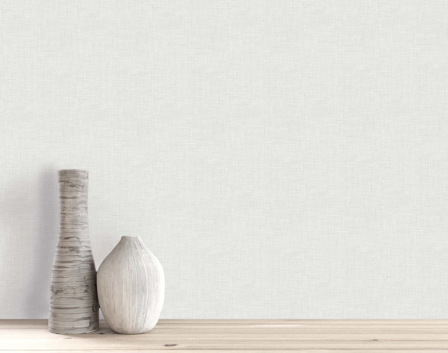 Two decorative vases sit on a wooden surface, set against a plain wall with Faux Linen Wallpaper.