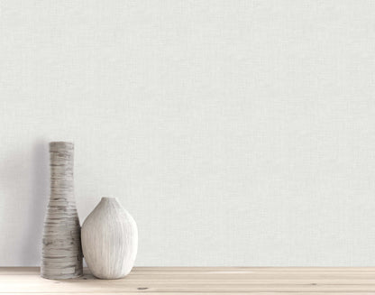 Two decorative vases sit on a wooden surface, set against a plain wall with Faux Linen Wallpaper.