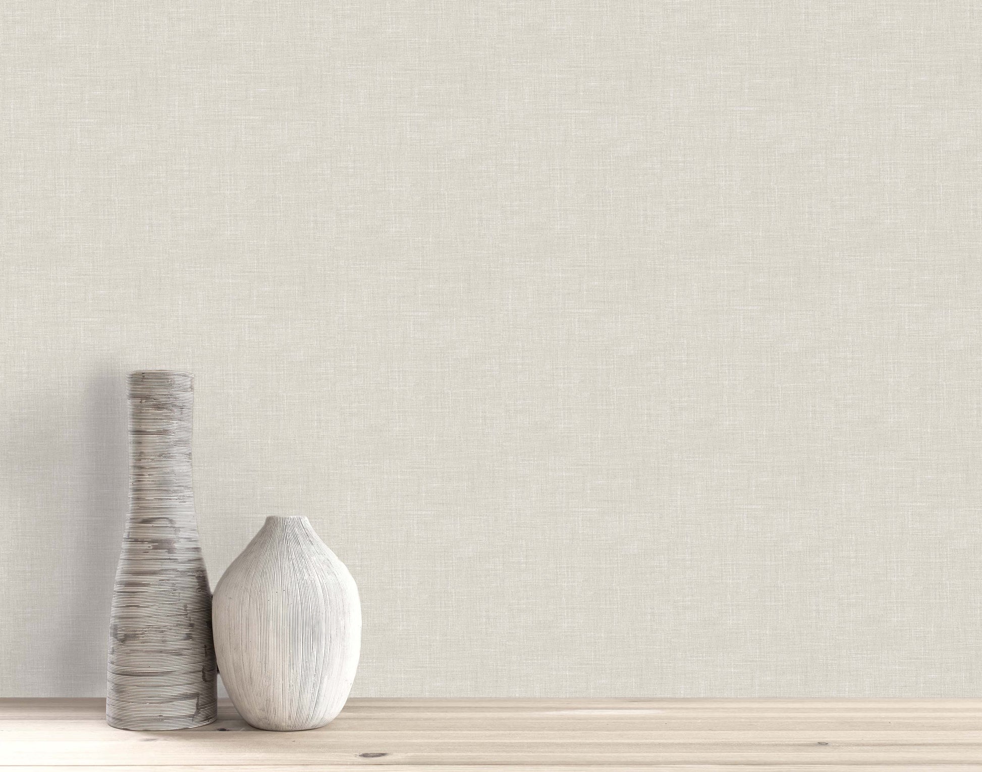 Two decorative vases sit on a wooden surface against a beige wall with Faux Linen Wallpaper.