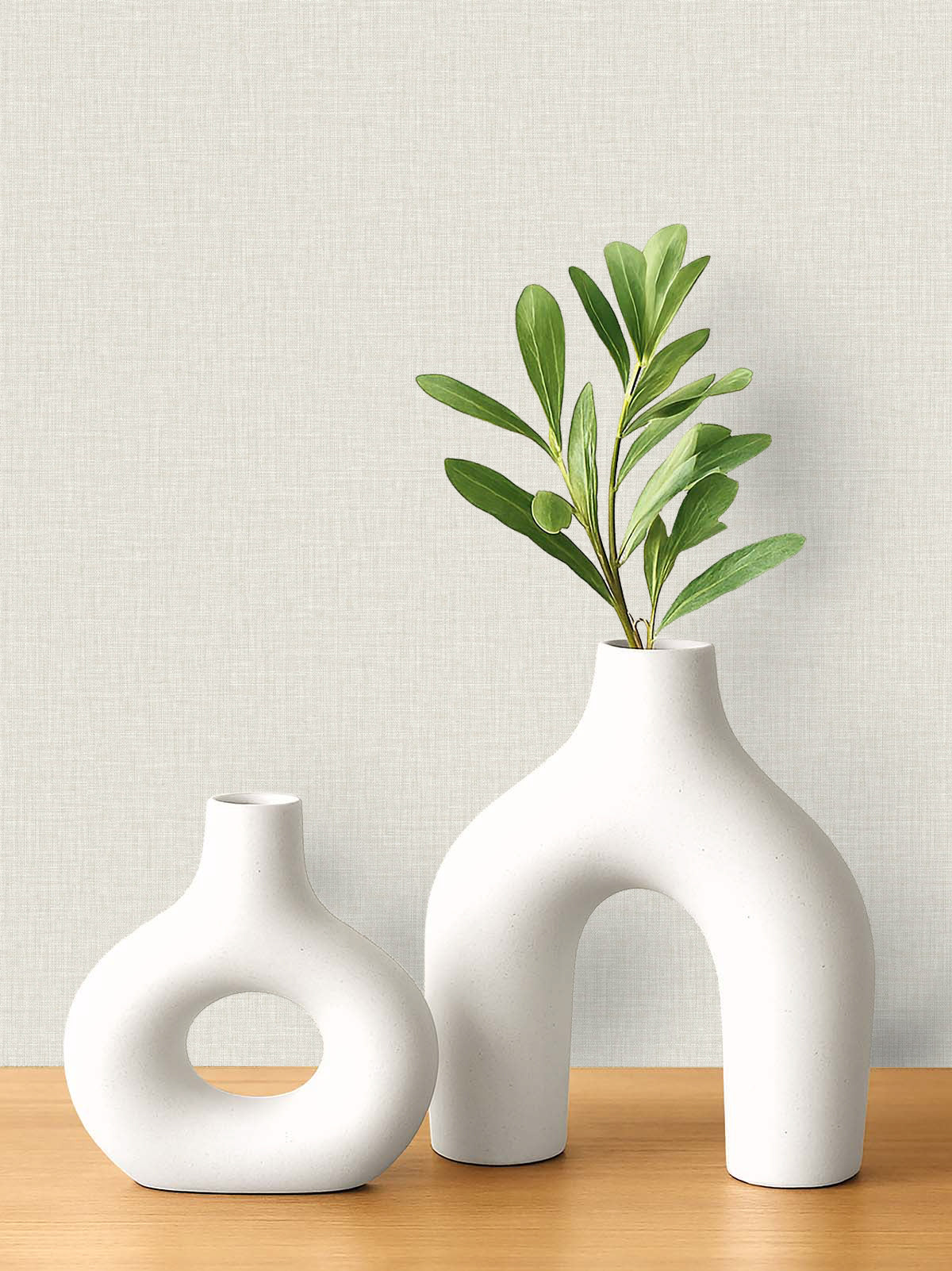Two modern white ceramic vases on wood complement the Pearly Linen Wallpaper with geometric shapes.