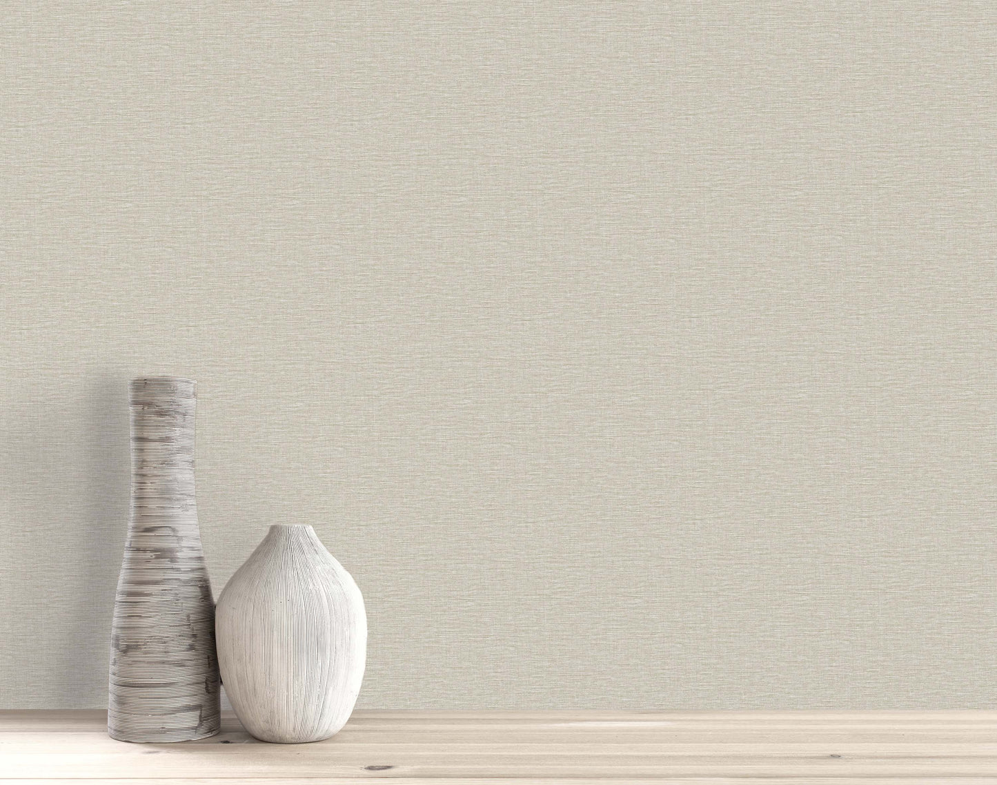 Two decorative vases on a light wooden surface with Pearly Linen Wallpaper in a plain beige textured finish.