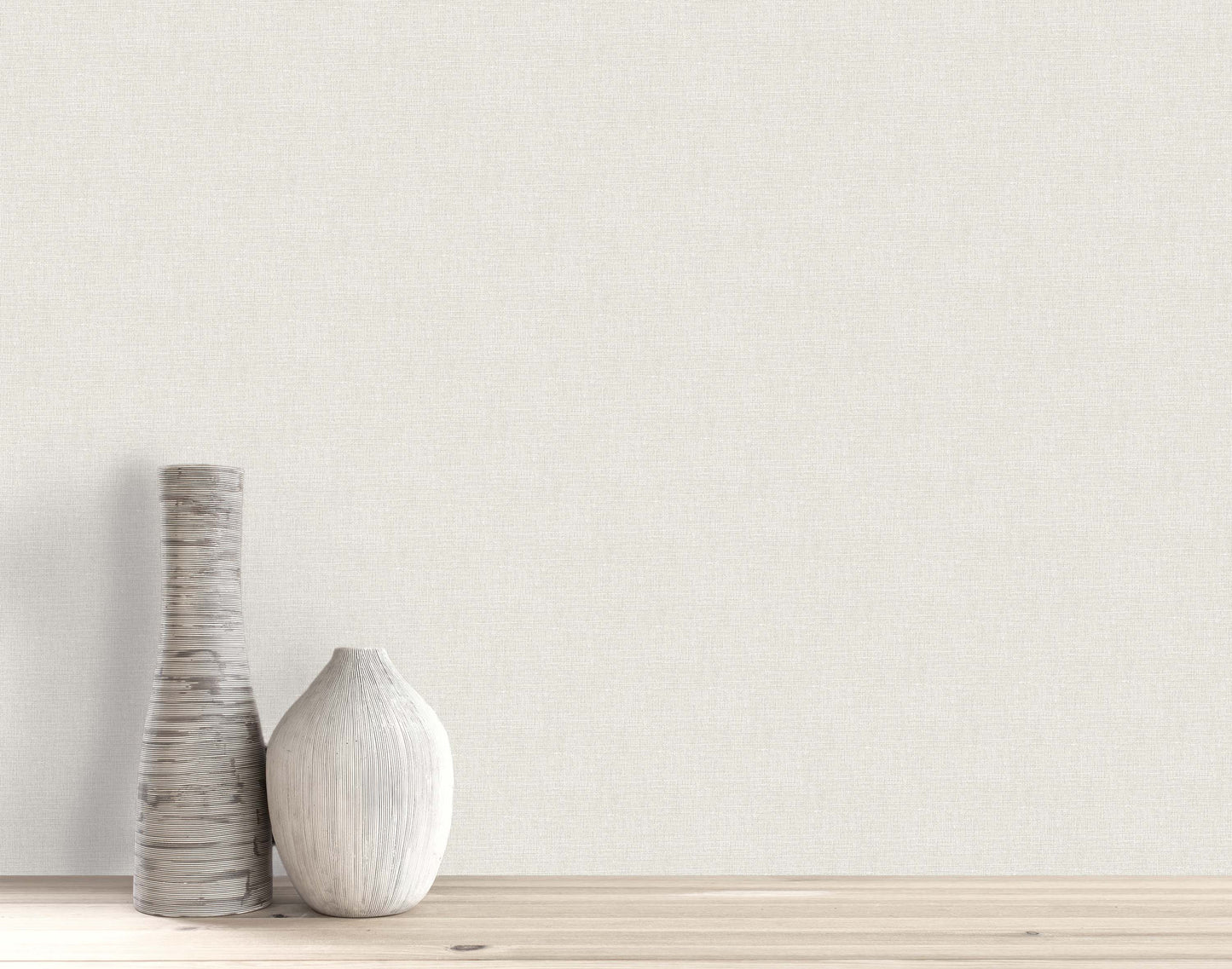 Two decorative vases sit on a wooden surface against a plain wall with Woven Linen Effect Wallpaper.