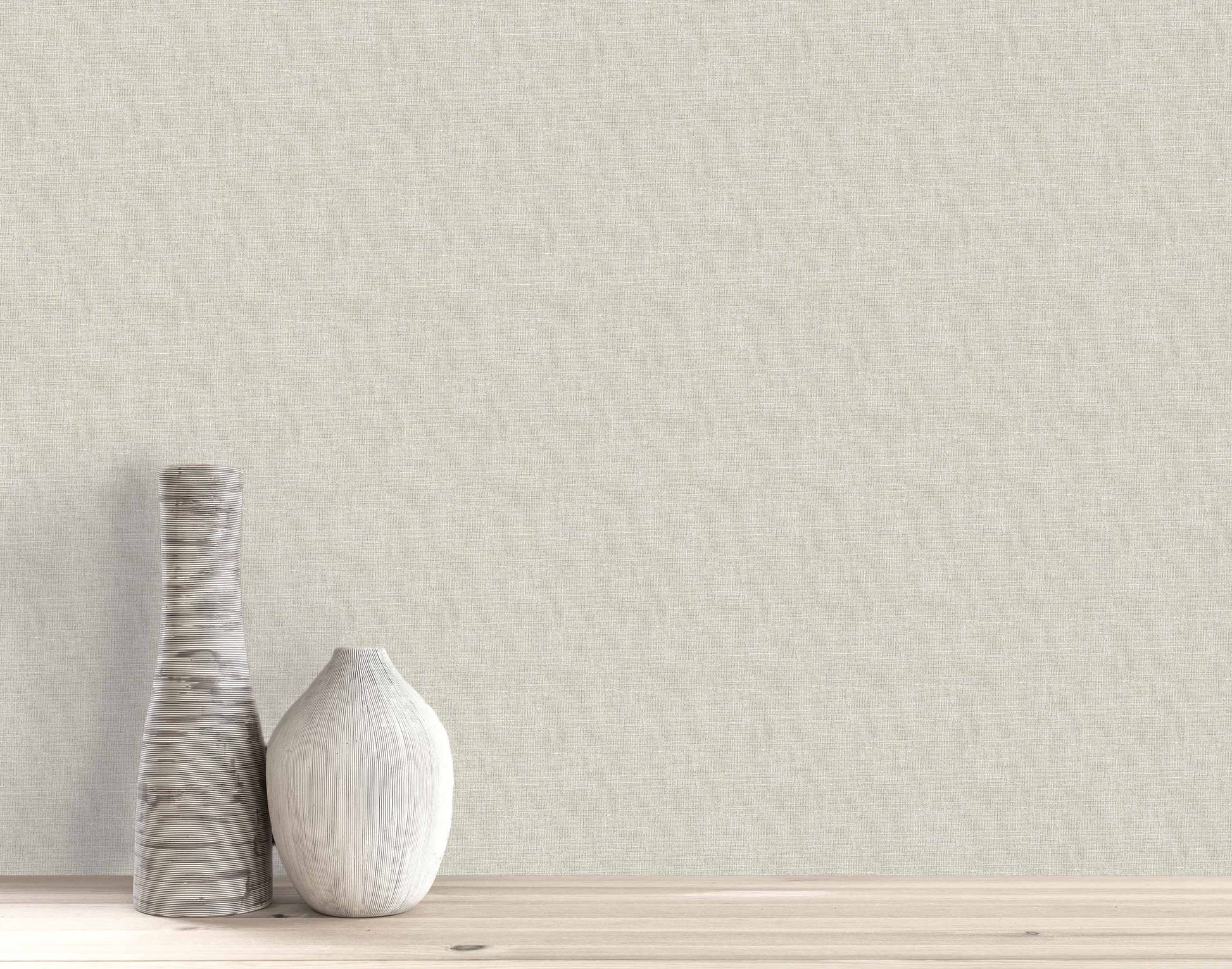 Two textured vases, tall and short, sit on wood against a beige Woven Linen Effect Wallpaper wall.