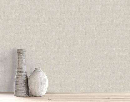Two textured vases, tall and short, sit on wood against a beige Woven Linen Effect Wallpaper wall.