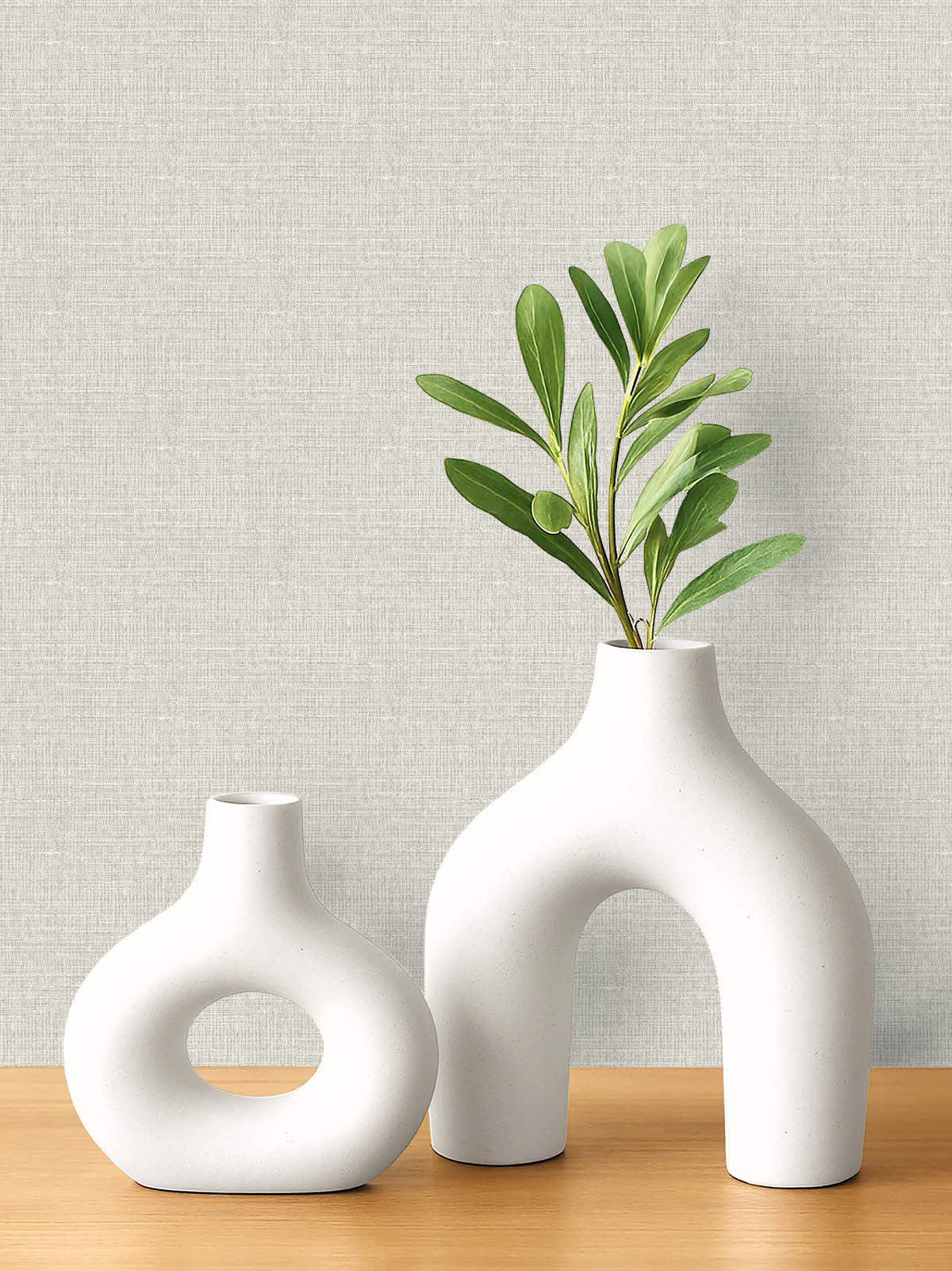 Two white ceramic vases on a wooden surface with Woven Linen Effect Wallpaper for a clean, fresh backdrop.