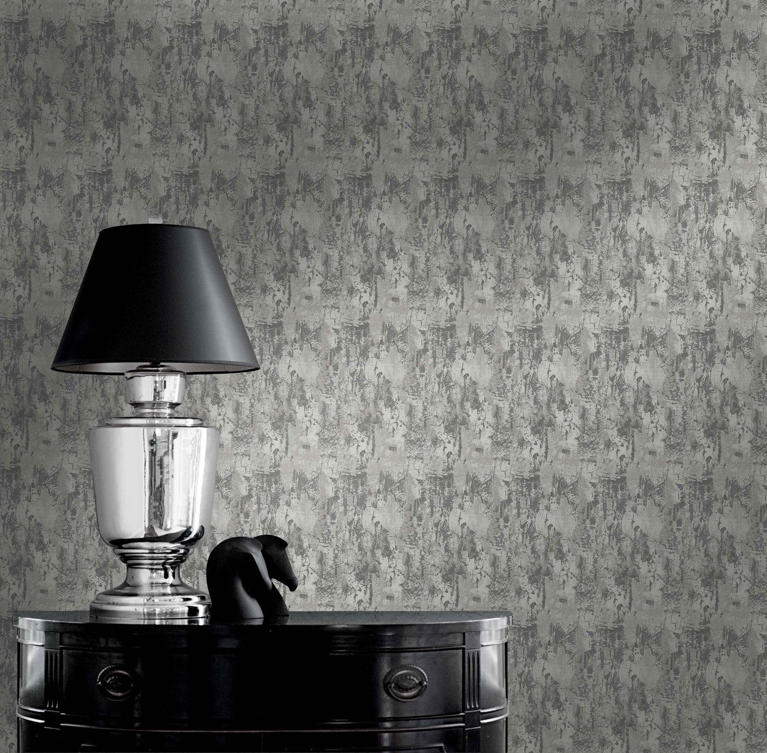 Silver lamp with black shade on glossy table beside sculpture against Faux Concrete Wallpaper.
