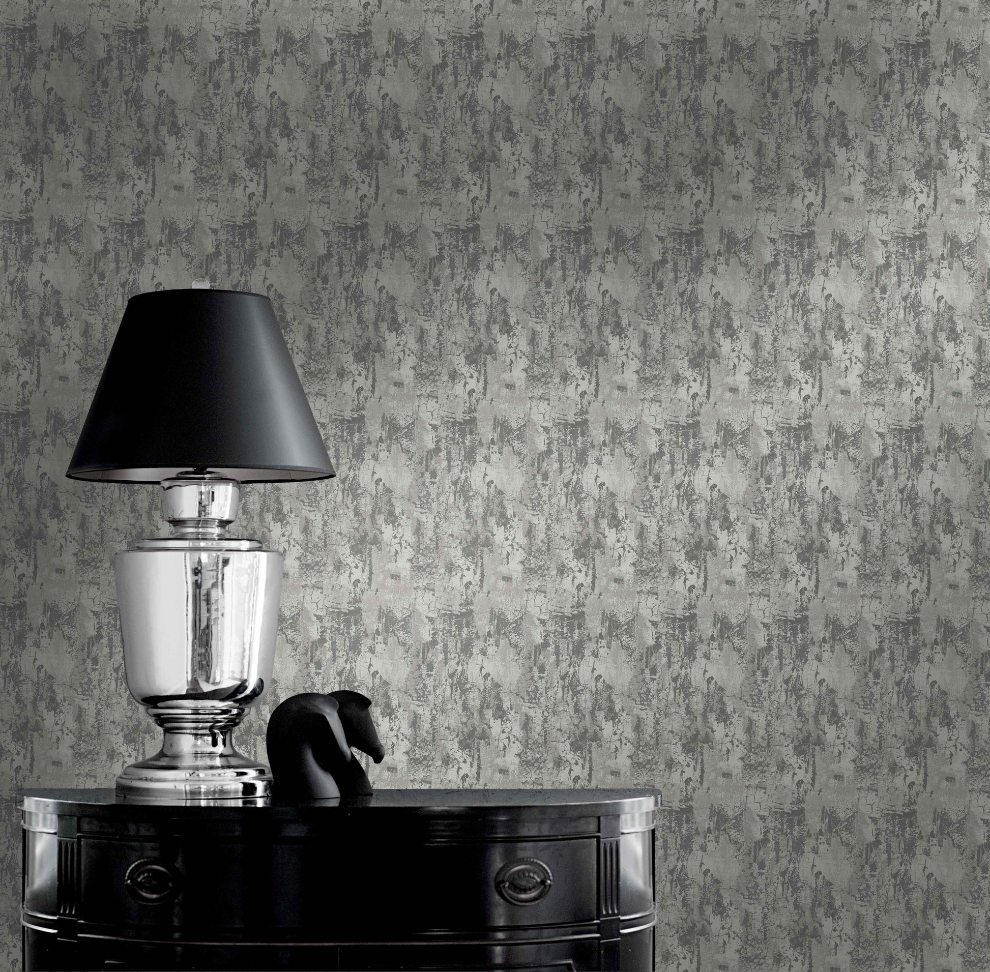 Silver lamp with black shade on glossy table beside sculpture against Faux Concrete Wallpaper.