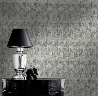 Silver lamp with black shade on glossy table beside sculpture against Faux Concrete Wallpaper.