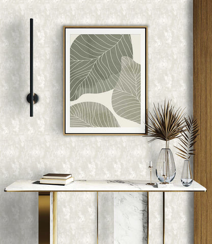Minimalist entryway with a marble console table, books, glass vases, and abstract leaf art on faux concrete wallpaper.
