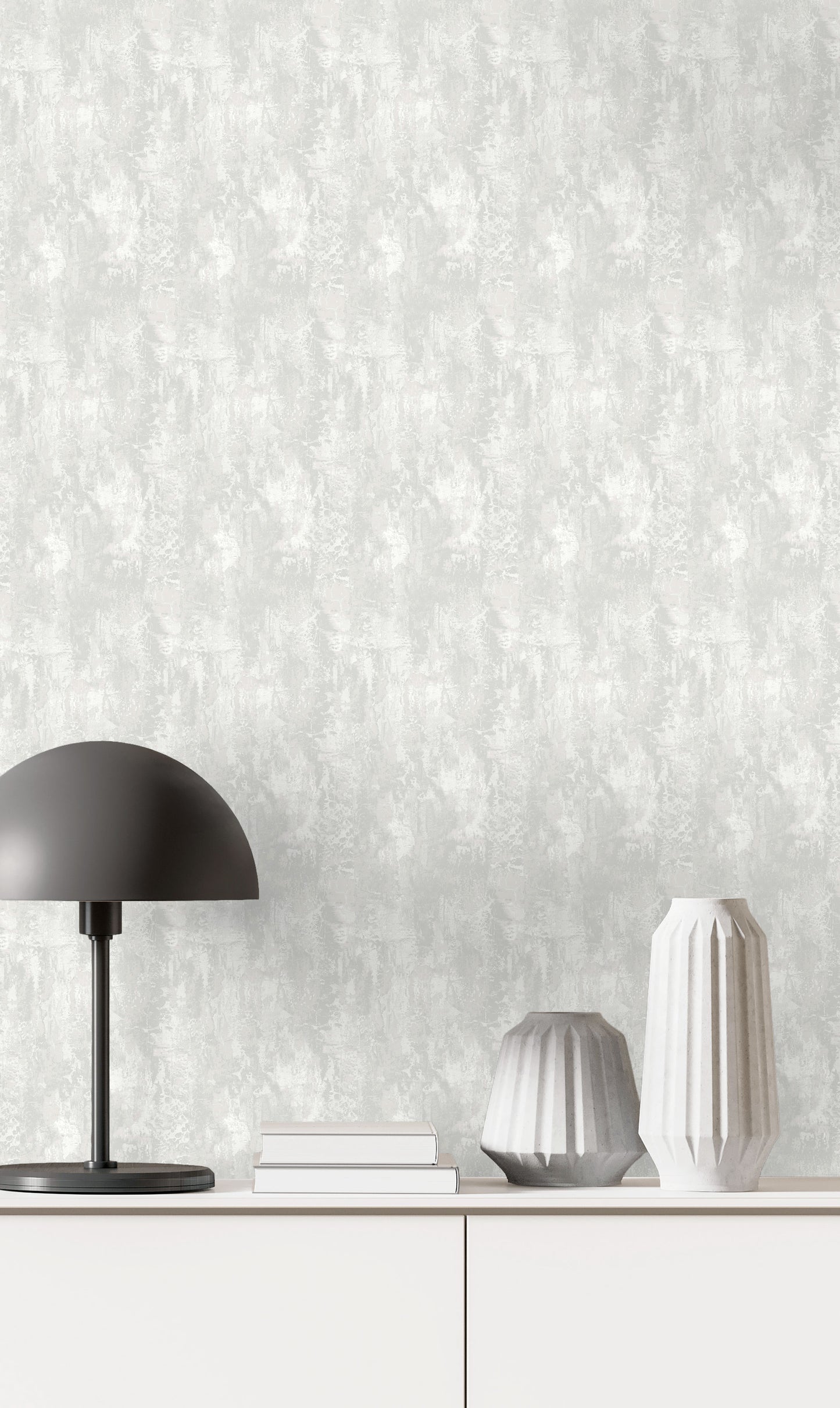 Minimalist decor with a black lamp, white vases, books, and Faux Concrete Wallpaper on a textured white cabinet backdrop.