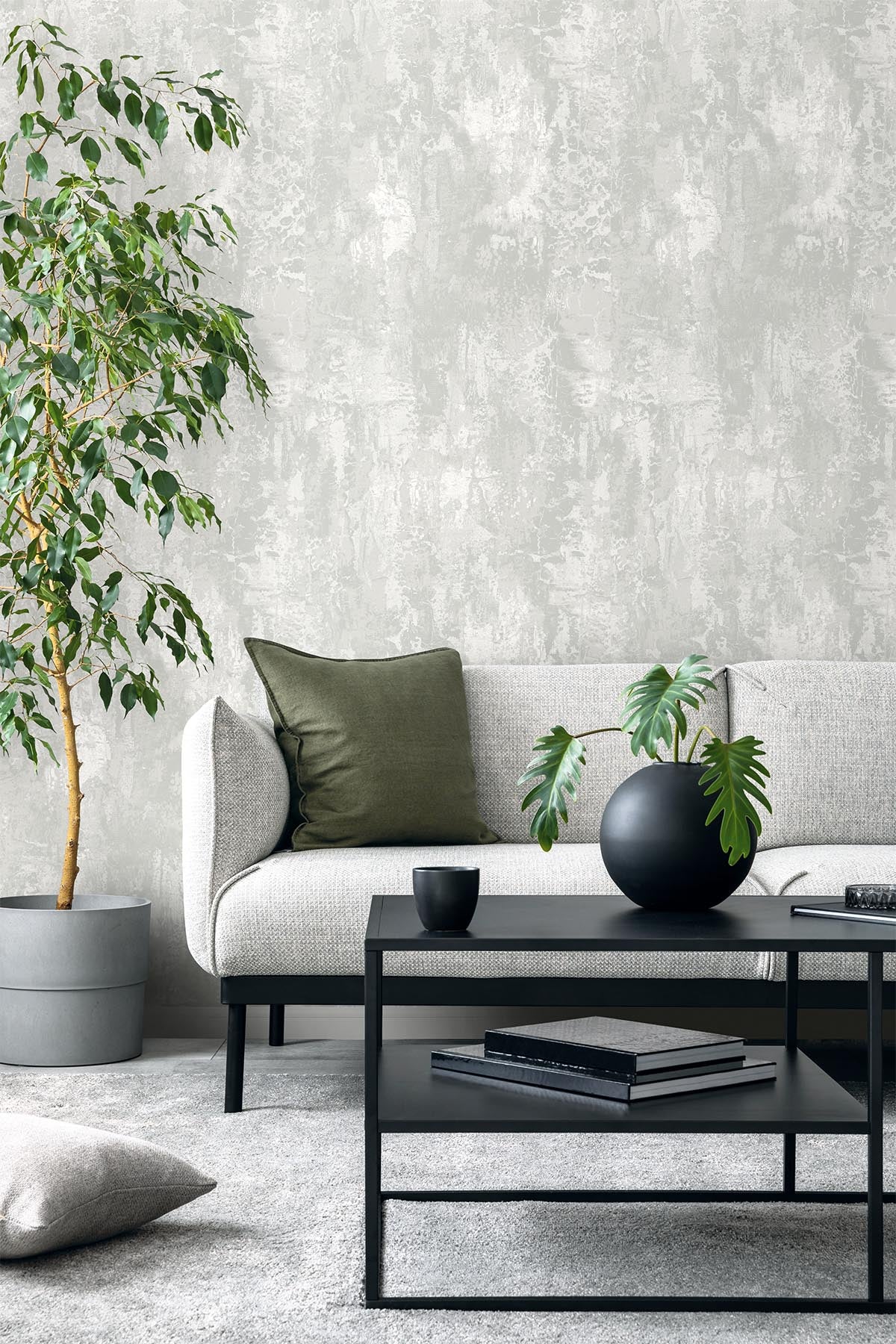 Modern living room with a gray sofa, green pillow, potted plant, and Faux Concrete Wallpaper.
