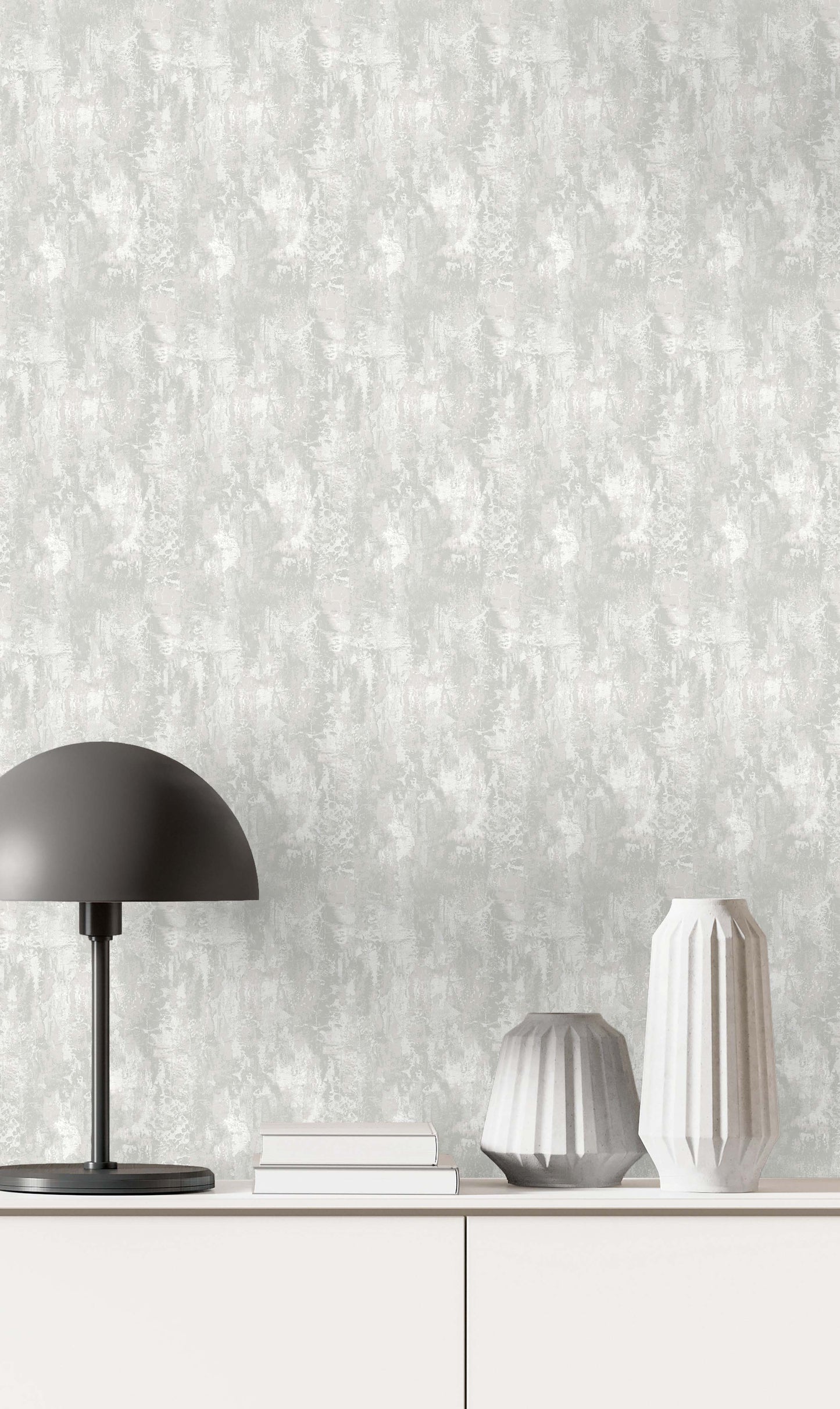 Minimalist scene with a black lamp, books, and vases on a white cabinet against Faux Concrete Wallpaper.