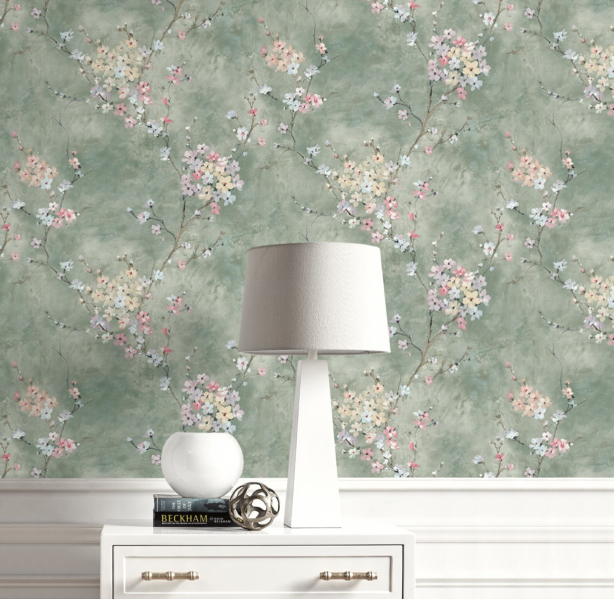 Lamp on a white dresser with Green Blossom Branch Peel & Stick Casa Mia Wallcovering on the background.