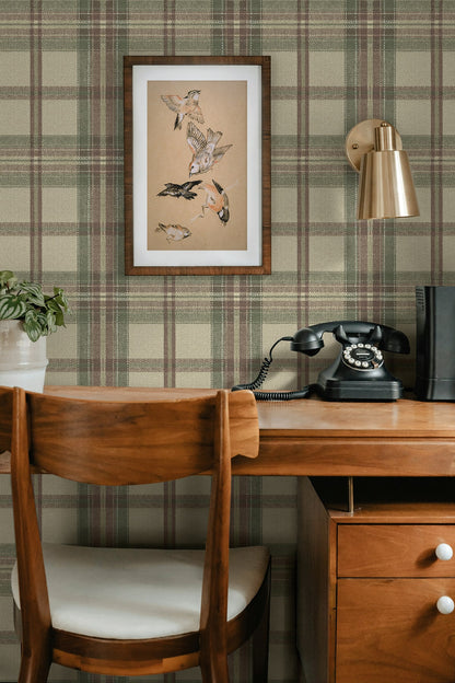 Wooden desk with chair, framed artwork, and vintage telephone against a wall decorated with Multicolor Greenish Broken Twill Plaid Peel & Stick Casa Mia Wallcovering.