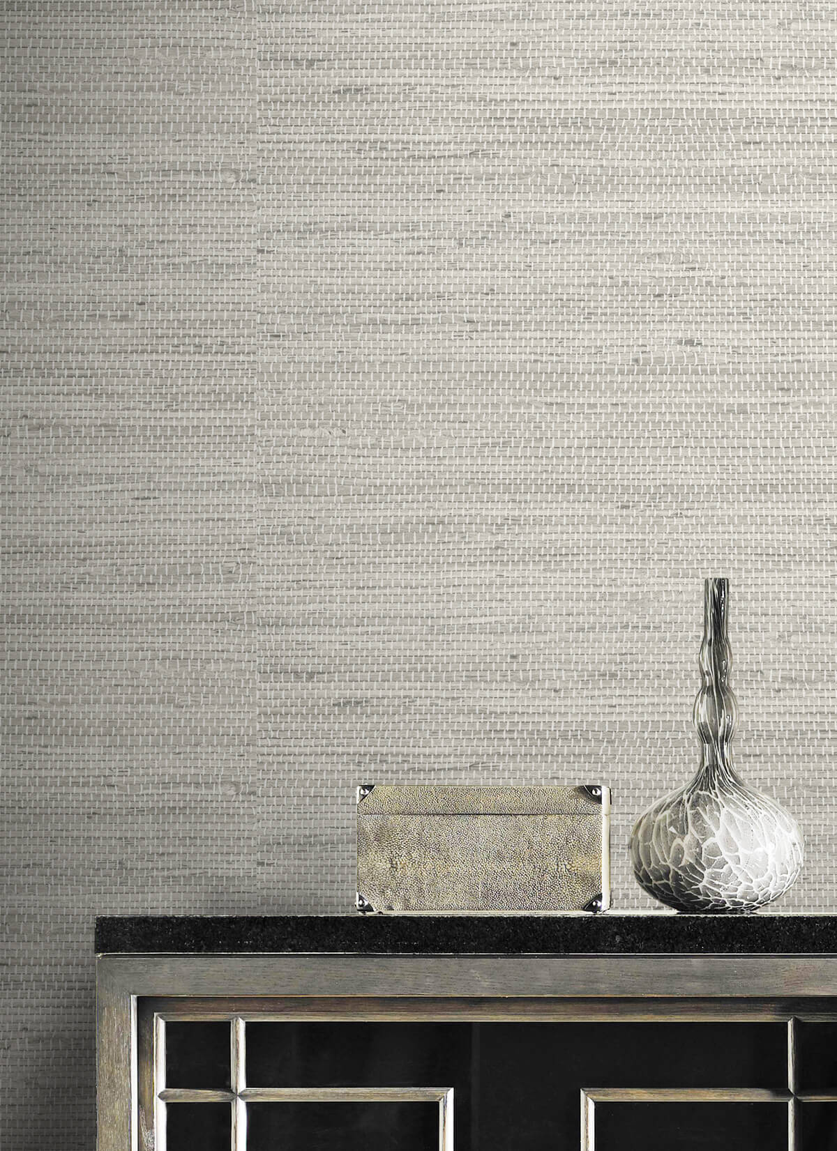 Wall decorated with Gray Weave Grasscloth Effect Peel & Stick Casa Mia Wallcovering and decorative elements including a vase and box.