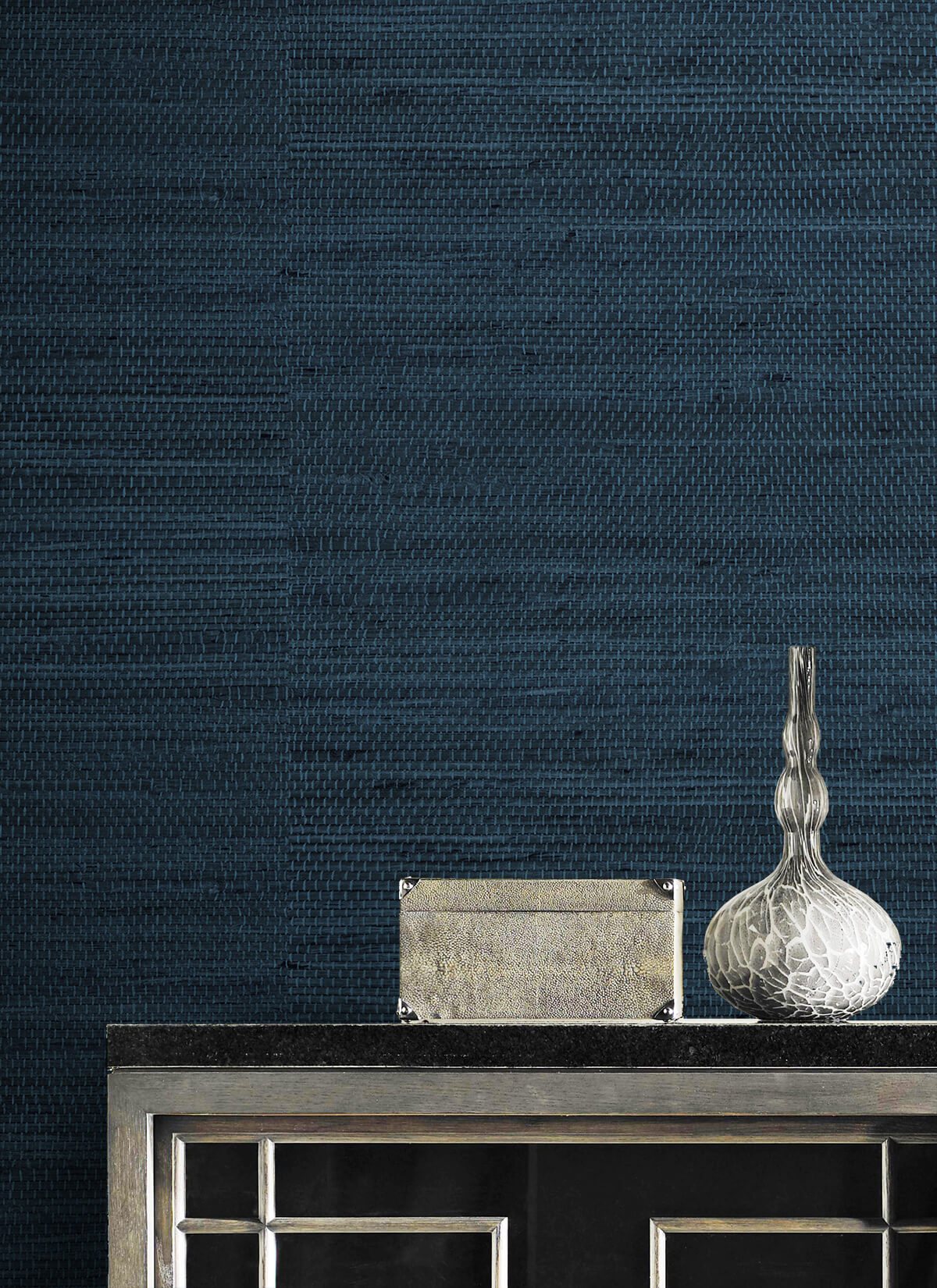 Decorative vase and box on a wall decorated with Blue Weave Grasscloth Effect Peel & Stick Casa Mia Wallcovering.