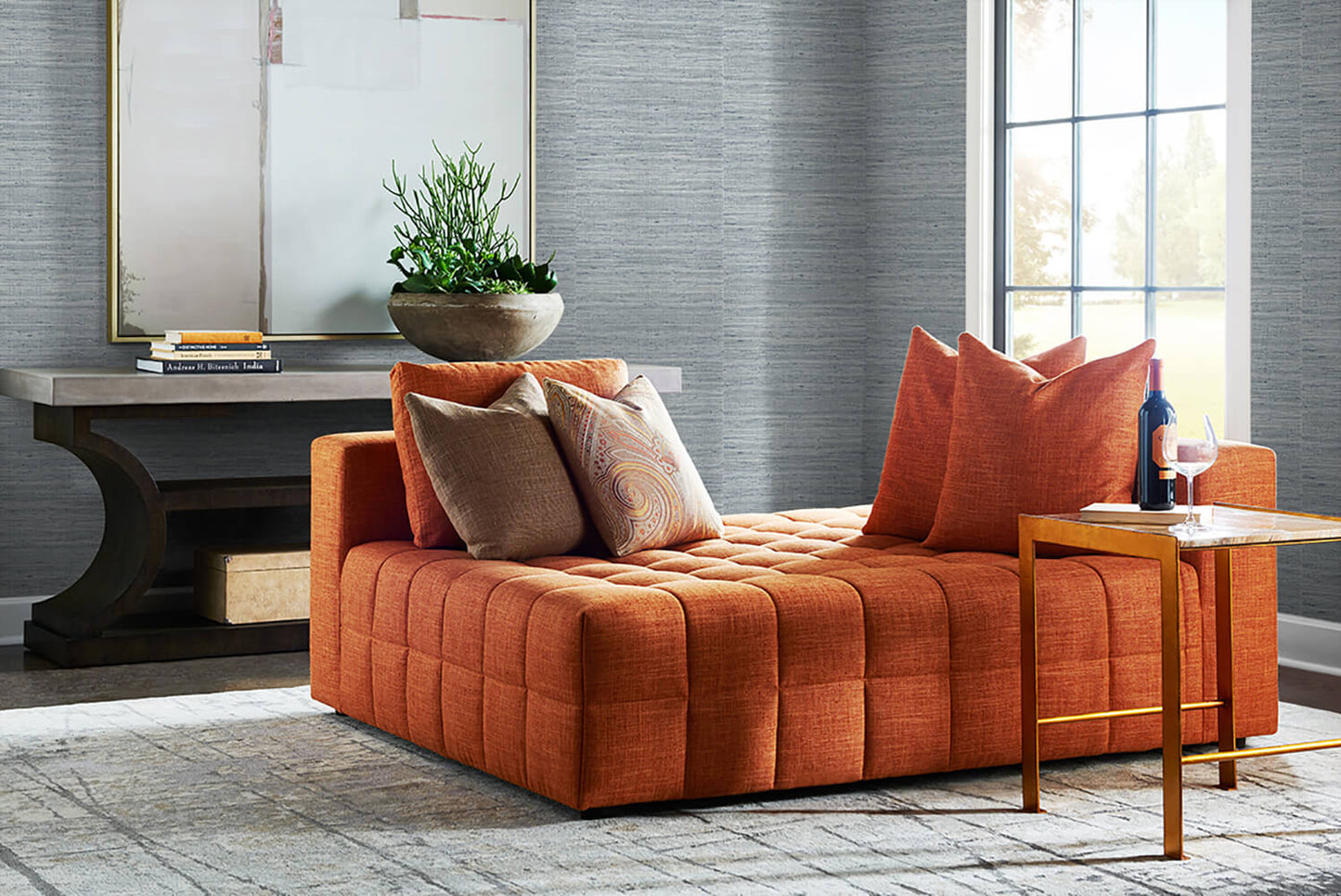 Orange sofa with decorative pillows in a living room setting and wall decorated with Light Blue Weave Grasscloth Effect Peel & Stick Casa Mia Wallcovering.