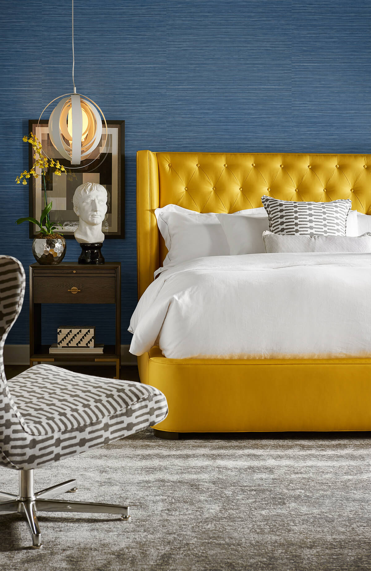 Modern bedroom with a yellow upholstered bed against a wall decorated with Blue Faux Sisal Peel & Stick Casa Mia Wallcovering.
