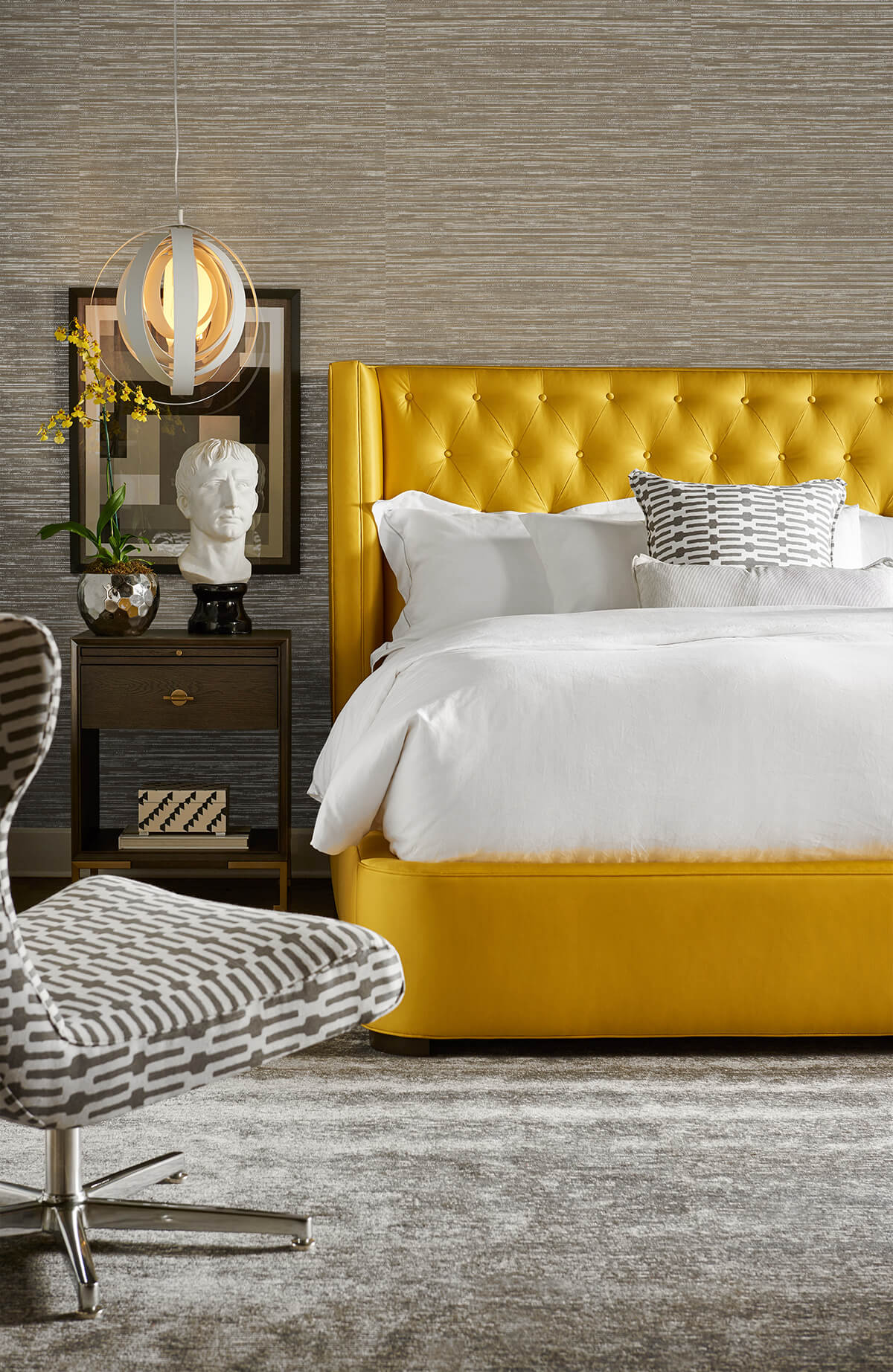 Modern bedroom with a yellow upholstered bed and decorative chair against a wall decorated with Silver Faux Sisal Peel & Stick Casa Mia Wallcovering.