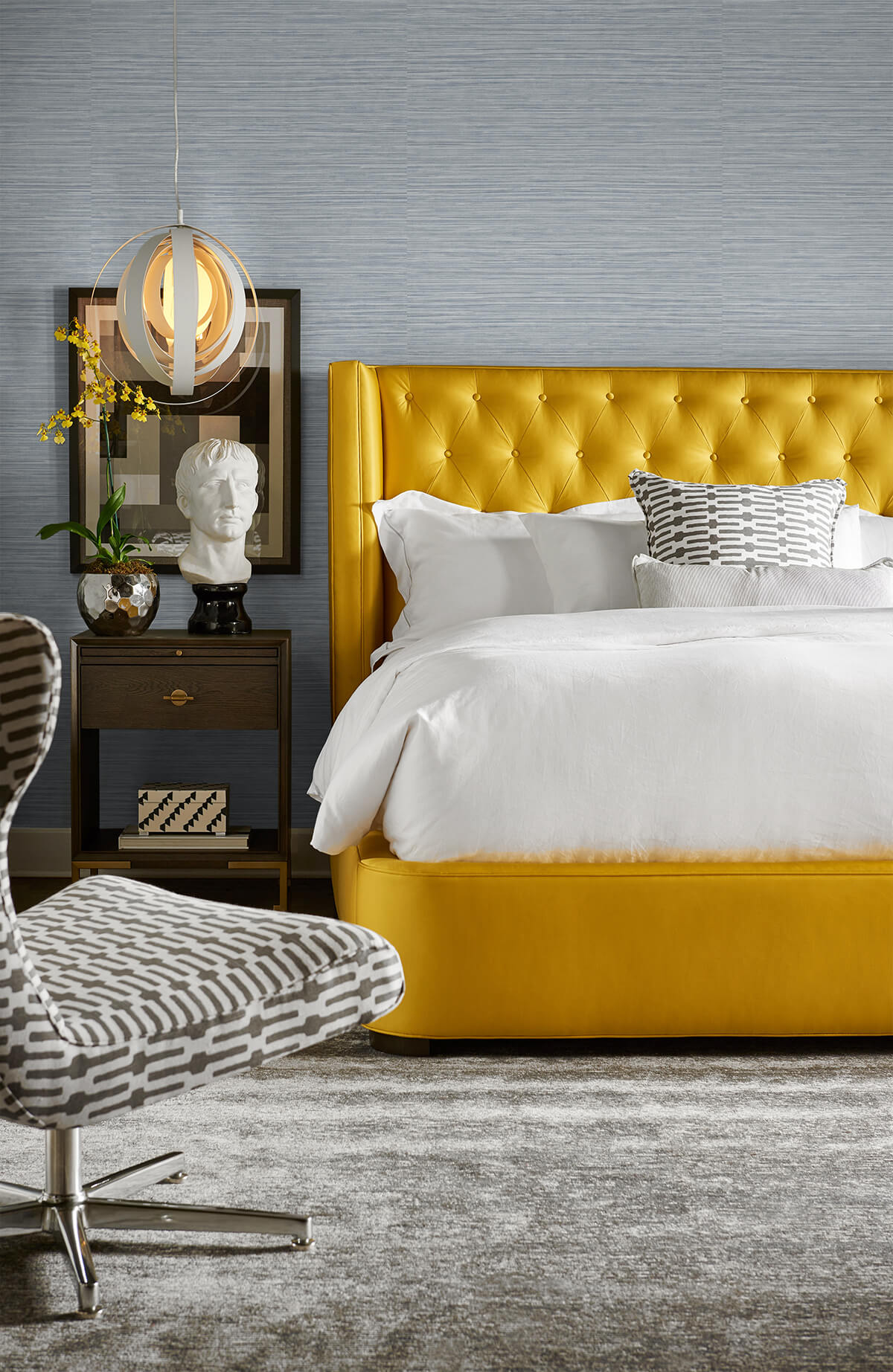 Modern bedroom with a yellow upholstered bed and decorative elements against a wall decorated with Light Blue Faux Sisal Peel & Stick Casa Mia Wallcovering.