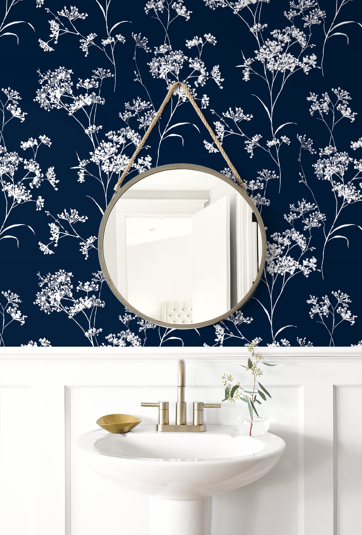 Round mirror on a wall with Blue Soft Scent Floral Peel & Stick Casa Mia Wallcovering and a sink below.