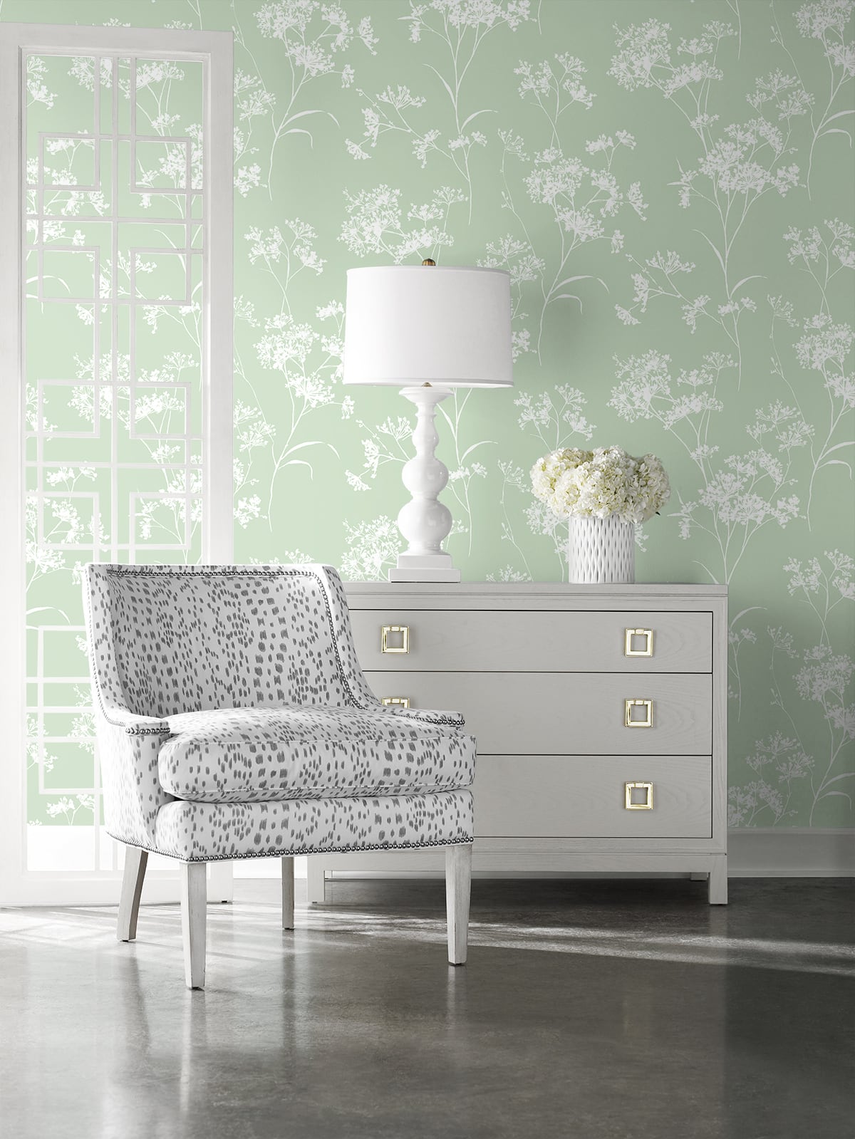 Living room with Green Soft Scent Floral Peel & Stick Casa Mia Wallcovering wallpaper, gray dresser, and patterned chair.