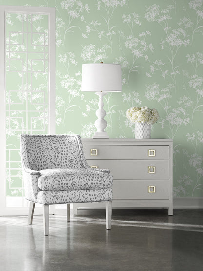 Living room with Green Soft Scent Floral Peel & Stick Casa Mia Wallcovering wallpaper, gray dresser, and patterned chair.