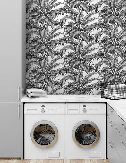 Laundry room with whitewashing machine and dryer against a wall decorated with Black Rainforest Palm Peel & Stick Casa Mia Wallcovering.