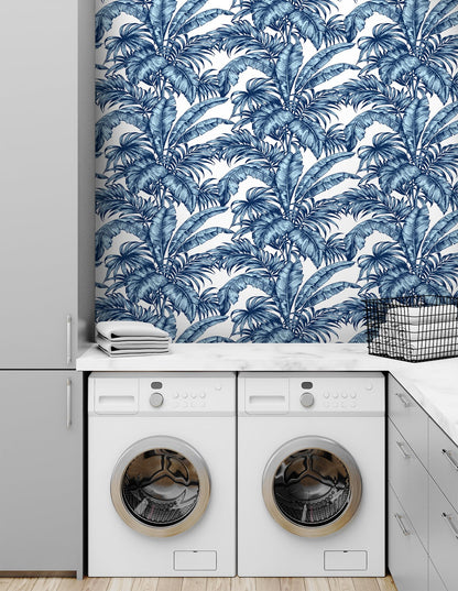 Laundry room with white appliances and wall decorated with Blue Rainforest Palm Peel & Stick Casa Mia Wallcovering.