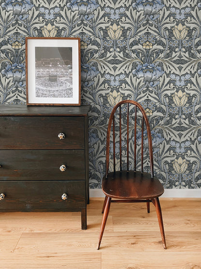 Wooden chair and dresser against a wall decorated with Black & Blue Bear's Breeches Peel & Stick Casa Mia Wallcovering.