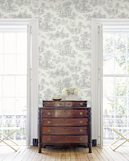 Wooden dresser against a wall decorated with Gray Toile de Jouy Peel & Stick Casa Mia Wallcovering.