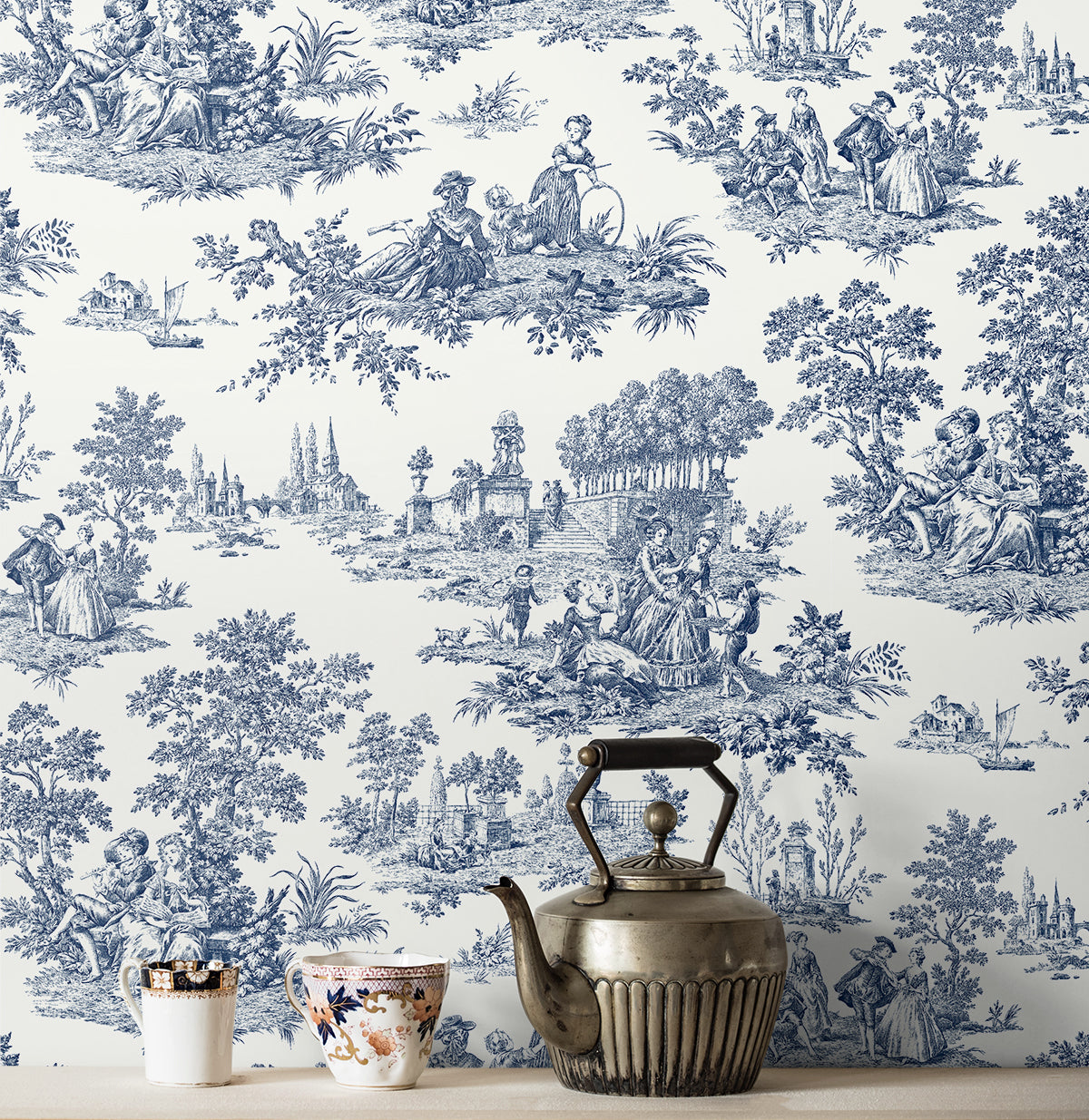 Vintage-style wallpaper with blue and white design featuring people and nature Blue Toile de Jouy Peel & Stick Casa Mia Wallcovering, with a teapot and cups in front.