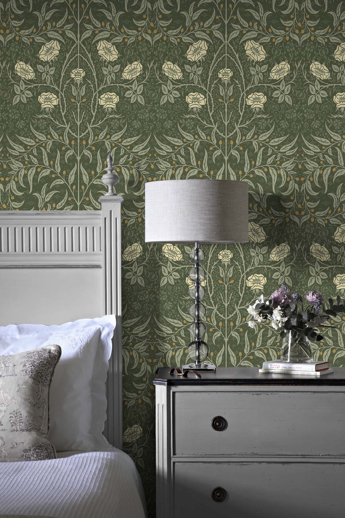 Bedroom with wall decorated Green Drawn Floral Peel & Stick Casa Mia Wallcovering, gray nightstand, and white lamp.