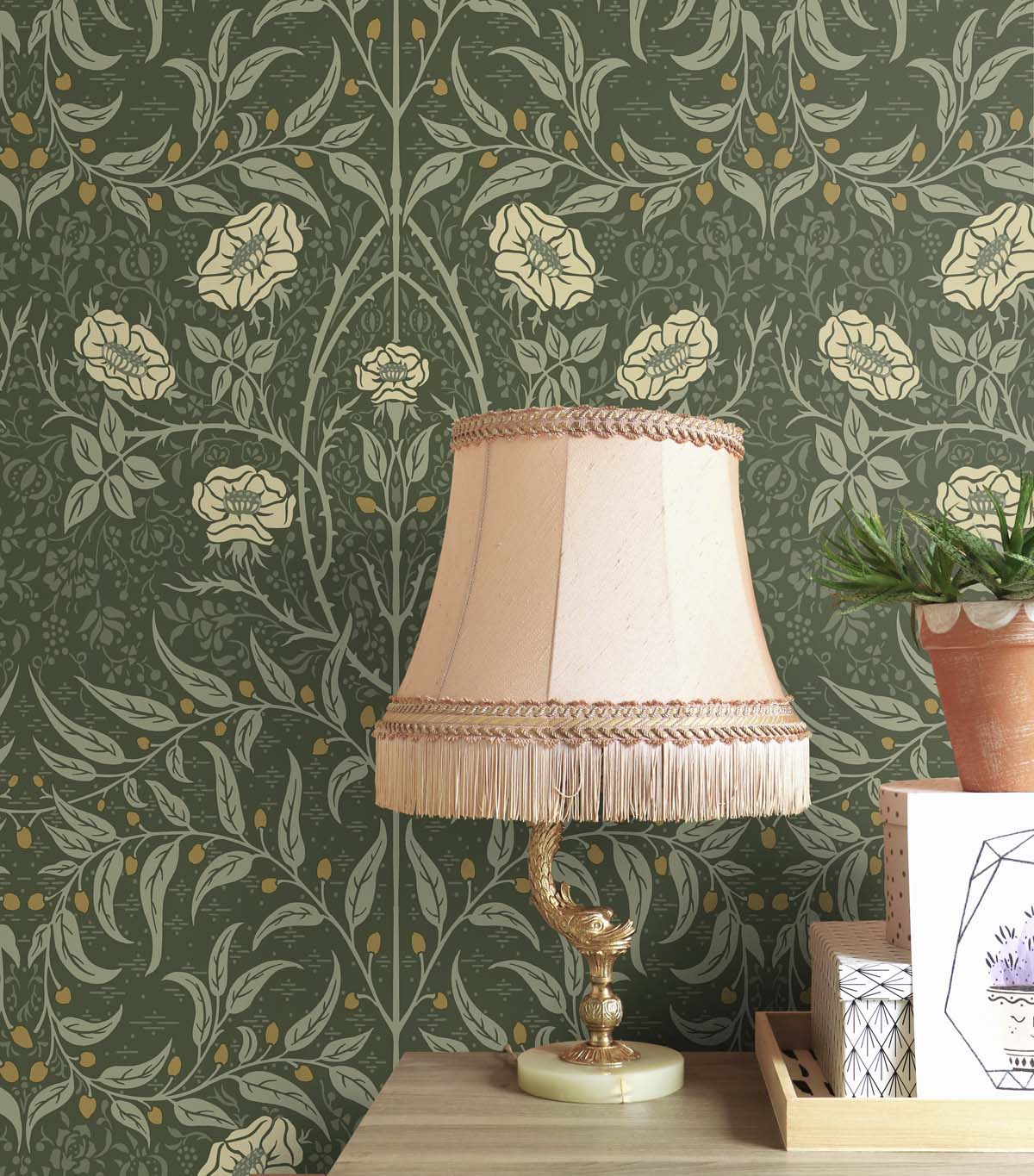 Decorative lamp with a beige shade on a wooden surface against a wall decorated with Green Drawn Floral Peel & Stick Casa Mia Wallcovering.